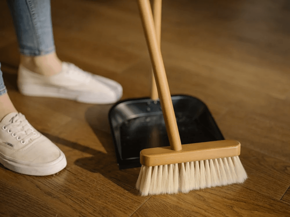 a person cleaning with a broom