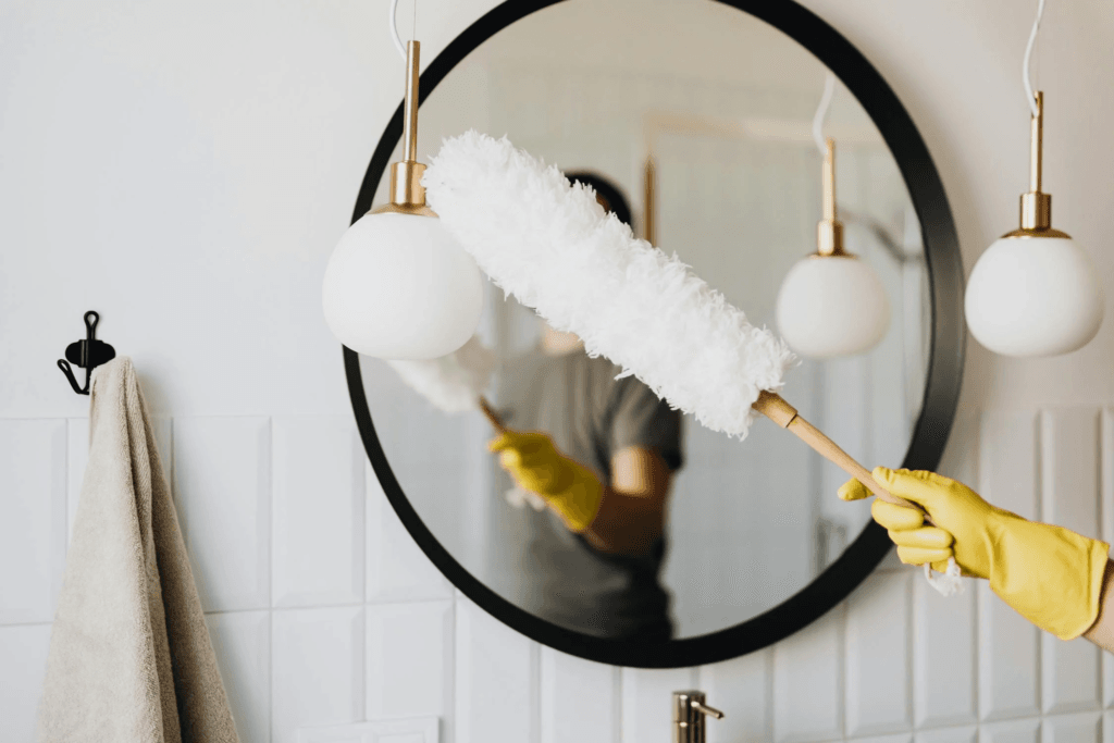 A person cleans a mirror