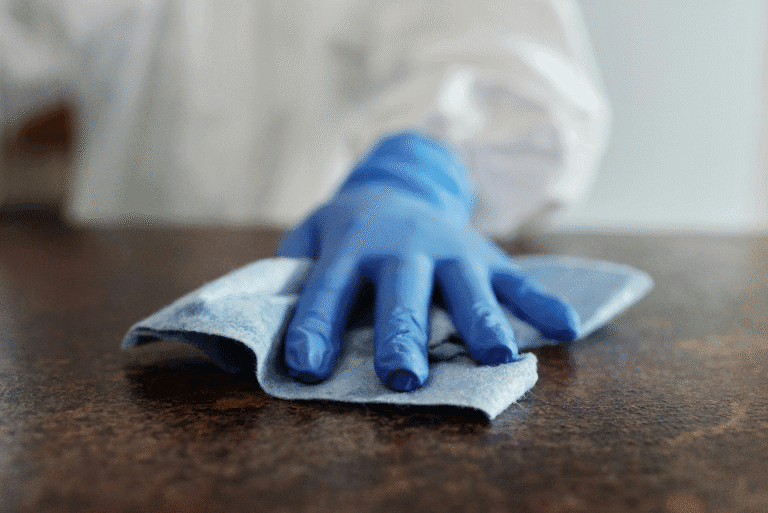 Person wearing a glove cleaning a surface